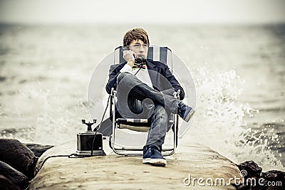 Teen Boy Relaxing at the Seaside with Old Phone Stock Photo