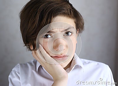 Teen boy with toothache holding his cheek Stock Photo