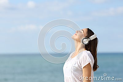 Teen breathing fresh air listening to music on the beach Stock Photo