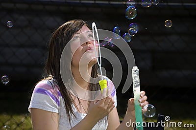 Teen girl blows bubbles Stock Photo