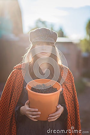 Teen girl with a bucket of black chokeberry in backlight Stock Photo