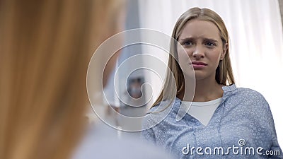 Teen girl disappointed by face skin problems reflecting mirror, hormonal changes Stock Photo