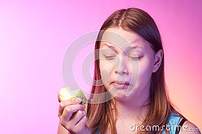 Teen girl eating disgusting apple Stock Photo