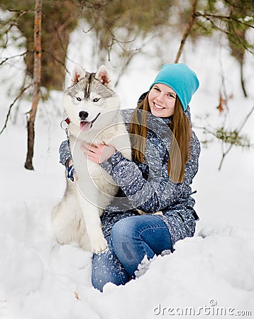 Teen girl embracing hasky dog in winter park Stock Photo