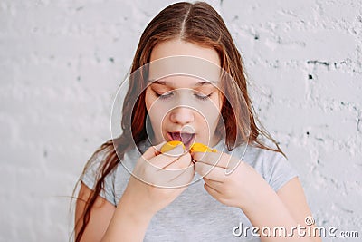 Teen girl has two macaroons at once, the concept of childhood obesity and overeating Stock Photo