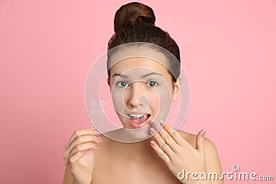 Teen girl holding acne healing patches on pink background Stock Photo