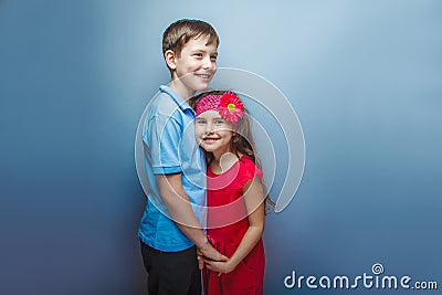 Teen girl holding hands teenage boy on gray Stock Photo