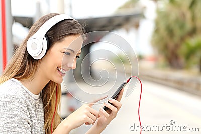 Teen girl listening to the music with headphones waiting a train Stock Photo