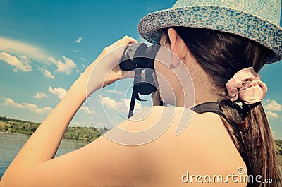 Teen girl looking through binoculars closeup toning Stock Photo