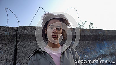 Teen girl looking at camera, dreaming to escape prison, juvenile delinquency Stock Photo