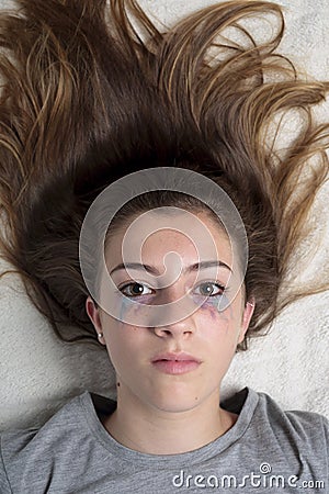 Teen girl lying with painted eyes. Stock Photo