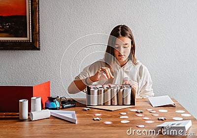 Teen girl making handmade advent calendar house from toilet paper rolls and carton box. Stock Photo