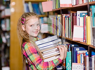 Teen girl with pile books in the library Stock Photo