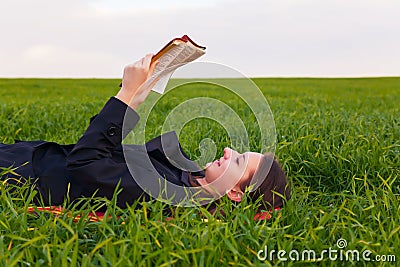 Teen girl reading the Bible outdoors Stock Photo