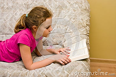 Teen girl reading a book on bed Stock Photo