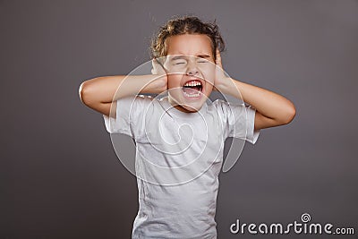 Teen girl screams closes ears gray background Stock Photo