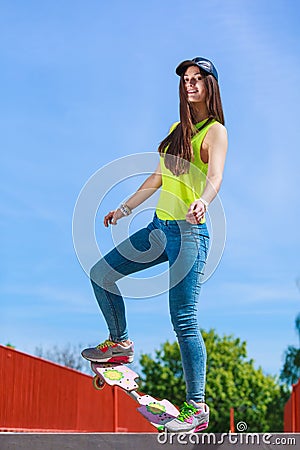 Teen girl skater riding skateboard on street. Stock Photo