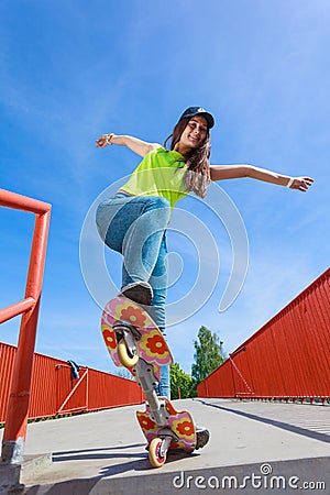 Teen girl skater riding skateboard on street. Stock Photo