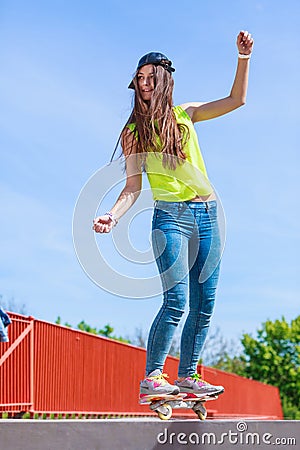 Teen girl skater riding skateboard on street. Stock Photo