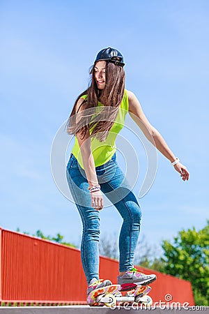 Teen girl skater riding skateboard on street. Stock Photo