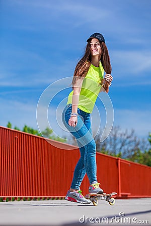 Teen girl skater riding skateboard on street. Stock Photo