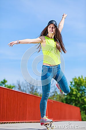 Teen girl skater riding skateboard on street. Stock Photo