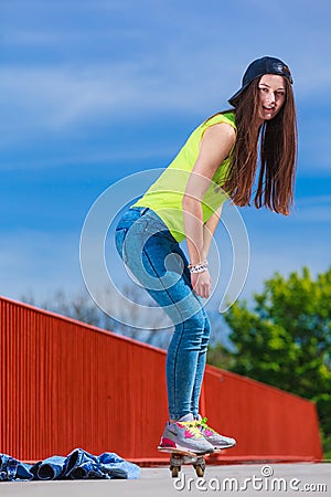 Teen girl skater riding skateboard on street. Stock Photo