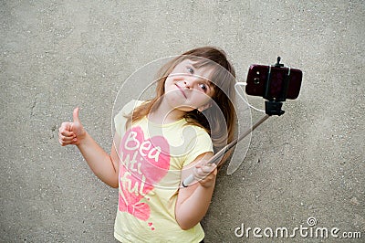 Teen girl stands with monopod in hands Stock Photo