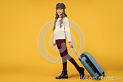 teen girl with suitcase for trip on yellow background, adventure Stock Photo