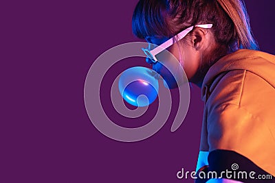 Teen girl wear stylish sunglasses hoodie blow bubble gum on purple background Stock Photo