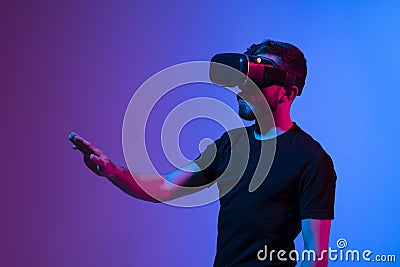 Teen male student use vr glasses and looks at empty copy space. Virtual gadgets for entertainment, work, free time and Stock Photo