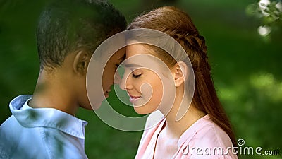 Teen multiracial couple touching foreheads in park, trustful relations, love Stock Photo