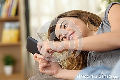 Teen texting in a smart phone lying on couch Stock Photo