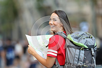 Teen tourist holding a guide and looking at camera Stock Photo