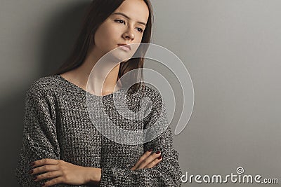 Teen upset,unhappy sad teenage girl stands with her arms crossed,frustrated young woman,problems and misfortunes in her family and Stock Photo