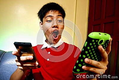 Teen using two smartphones Stock Photo