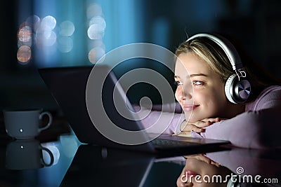Teen wearing headphones watching media on laptop Stock Photo