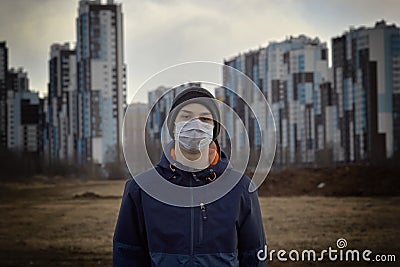 Teen wearing a medical mask against the background of a city against quarantine Stock Photo