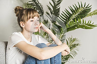 Teen woman anxious worried woman sitting on couch at home. Stock Photo