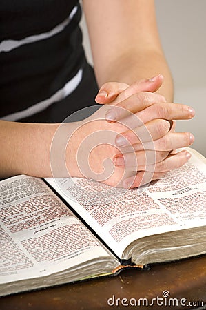 Teen woman praying over Bible Stock Photo
