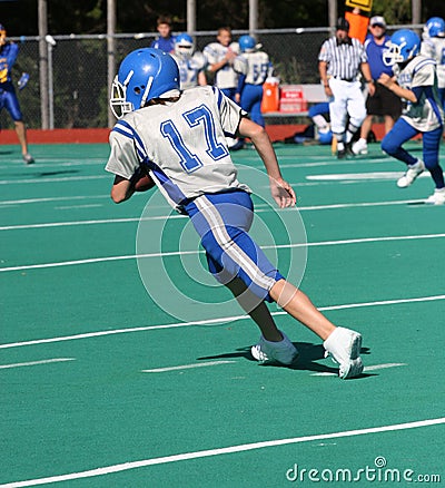 Teen Youth Football Player Running with the Ball Stock Photo