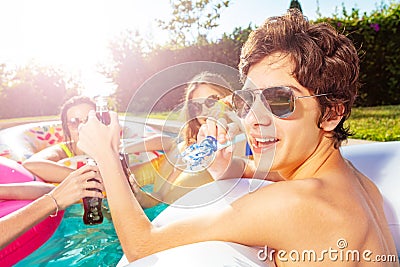 Happy boy with friends pool party blow noisemaker Stock Photo