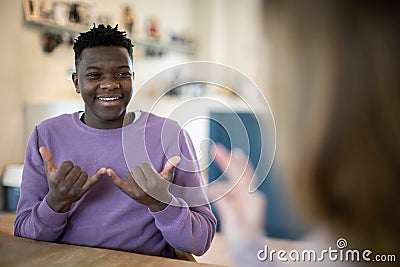 Teenage Boy And Girl Having Conversation Using Sign Language Stock Photo