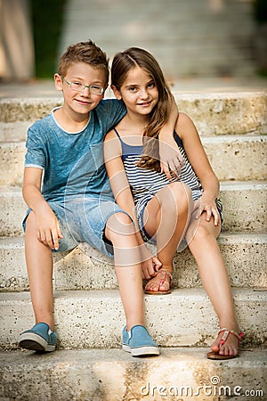 Teenage boy and girl sitting on stairs in park Stock Photo