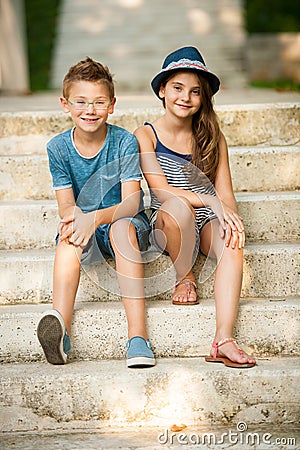 Teenage boy and girl sitting on stairs in park Stock Photo