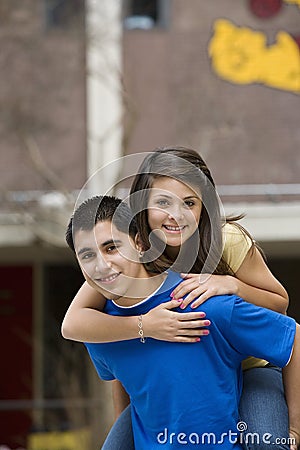 Teenage Boy Giving Girlfriend Piggy Back Ride Stock Photo