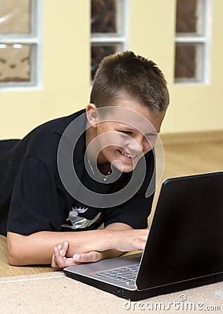 Teenage boy and laptop on floor Stock Photo