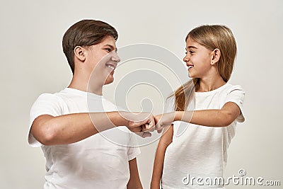 Teenage boy and little girl bumping fists Stock Photo