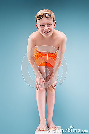 Teenage boy in orange shorts and swimming glasses Stock Photo