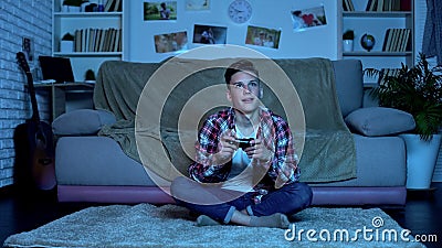 Teenage boy playing video game late at night addiction, lack of parental control Stock Photo